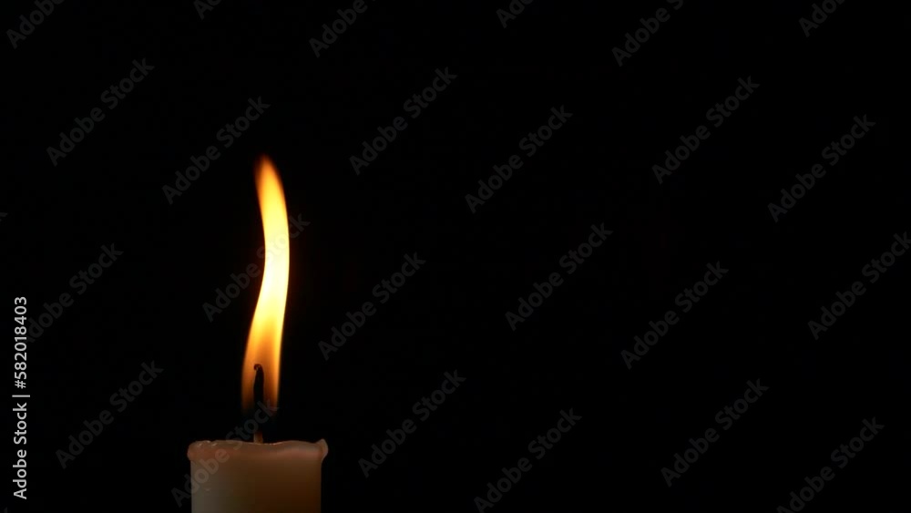 Close-up single candle burning on dark black background, candle fire flame light Close-up single candle burning on dark black background, candle fire flame light