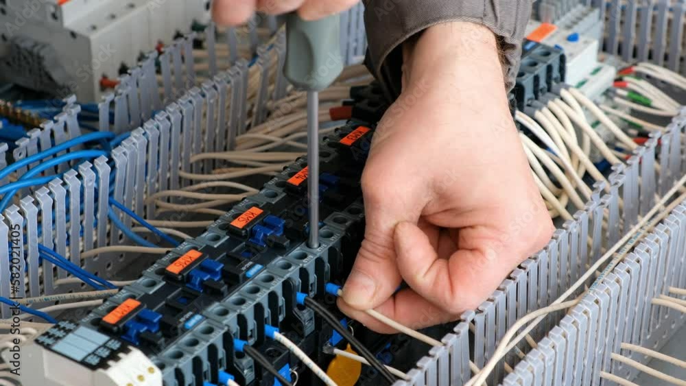 Technician assembles the mounting panel. Installing cables with the tip ...