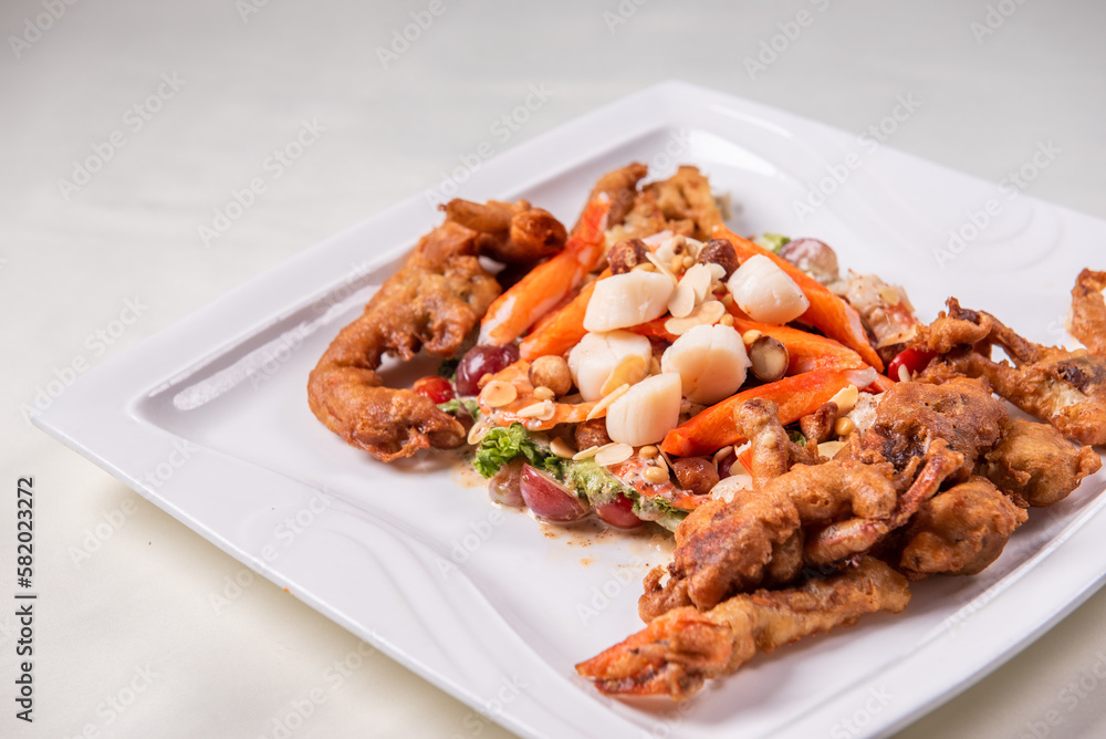 chinese and western mixed seafood combination cold platter with deep fried soft shell crab scallop salad on wood table asian banquet halal menu