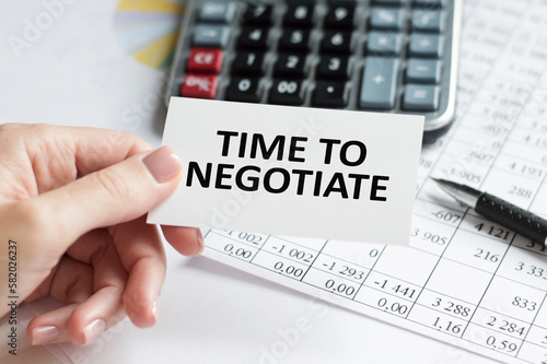 time to negotiate the text on the card is in the hand of a man in white clothes.