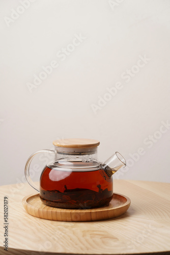 Glass teapot on wooden table  white  background