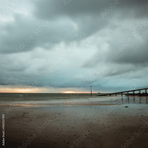 view of a boat jetty leading out to sea on a stormy day