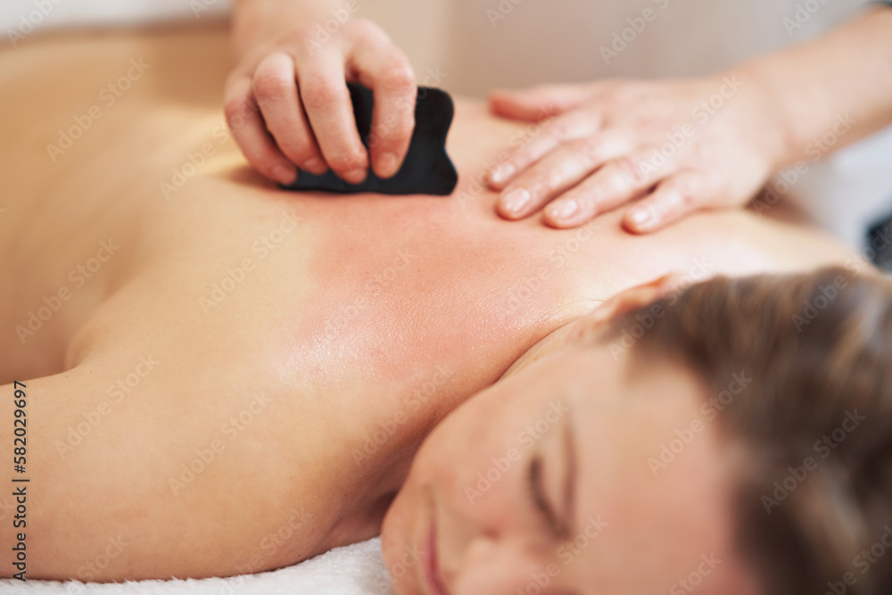 Woman having a gua sha massage in salon Woman having a gua sha massage in salon