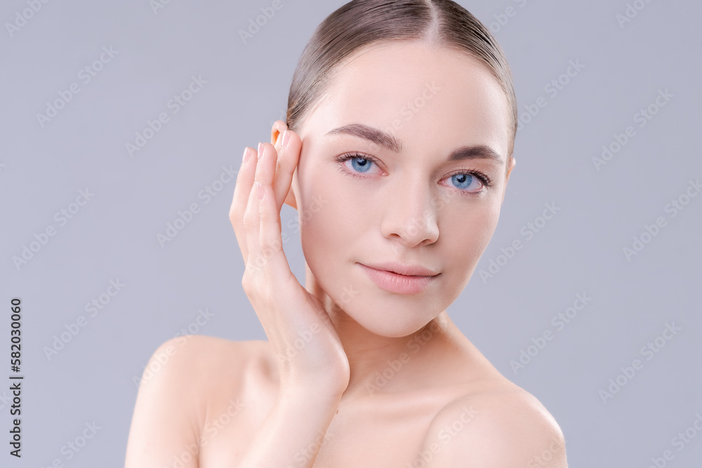 To camera isolated on background. Young woman close-up portrait. Healthy facial skin care beauty, age skin care cosmetic touches with hand, cosmetology concept To camera isolated on background. Young woman close-up portrait. Healthy facial skin care beauty, age skin care cosmetic touches with hand, cosmetology concept