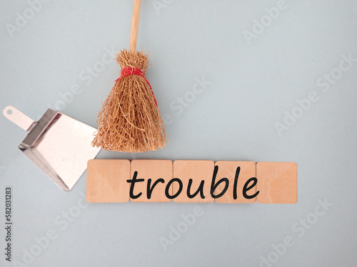 troubleトラブルの文字を箒とちりとりで掃除するイメージ