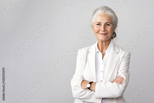 Portrait of a confident elder businesswoman in a suite on the solid white background. Copy space around.