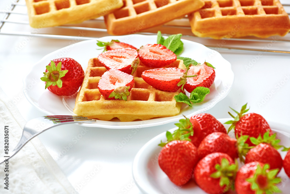 Breakfast with freashly baked belgian waffles on white table. Cooking concept. Healthy dessert, summer time Breakfast with freashly baked belgian waffles on white table. Cooking concept. Healthy dessert, summer time