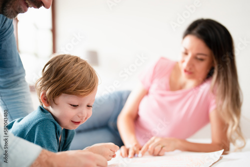 Happy family time, young toddler learning and having fun with parents enjoy relaxing day on bed, parenthood, self-esteem, happiness, quality time.