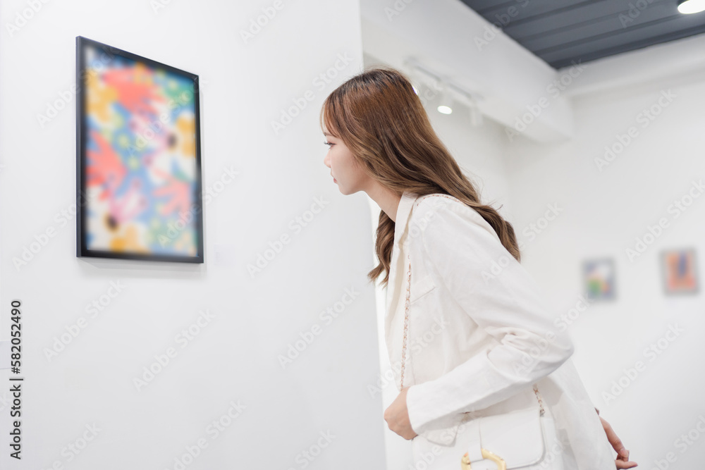 Woman visiting art gallery her looking pictures on wall watching photo frame painting at artwork museum people lifestyle concept. Woman visiting art gallery her looking pictures on wall watching photo frame painting at artwork museum people lifestyle concept.