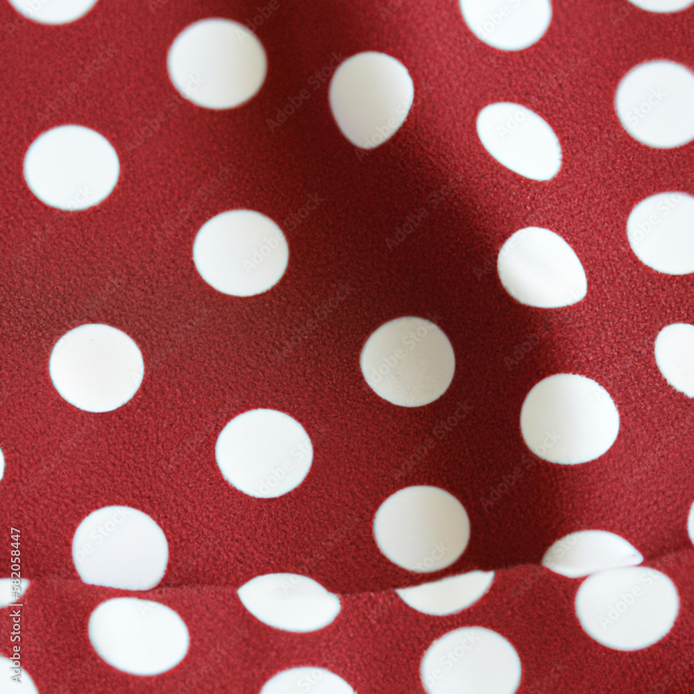 White polka dots on red background, textile fabric surface background.