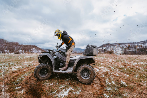 Fototapeta Naklejka Na Ścianę i Meble -  A man drives an ATV in the mud. Drift driving an ATV quad in mud and snow