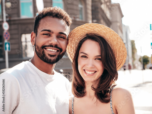 Smiling beautiful woman and her handsome boyfriend. Woman in casual summer clothes. Happy cheerful family. Female having fun. Sexy couple posing in the street at sunny day. In hat