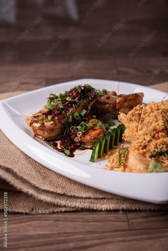 two in one varieties wok fried big prawn with nonya sweet and sour dark sauce and cereal butter prawn with curry leaf on wood table chinese halal banquet seafood menu two in one varieties wok fried big prawn with nonya sweet and sour dark sauce and cereal butter prawn with curry leaf on wood table chinese halal banquet seafood menu