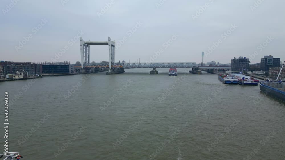 Barge Cruising In The Oude Maas River Towards The Dordrecht Railway Bridge In the Netherlands. - aerial Barge Cruising In The Oude Maas River Towards The Dordrecht Railway Bridge In the Netherlands. - aerial