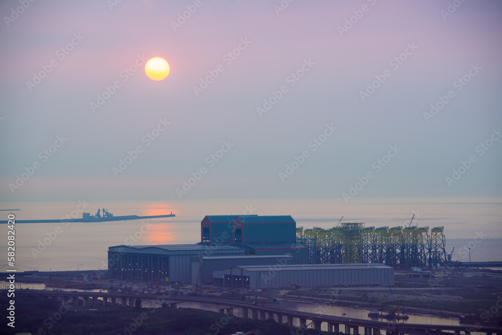 Airplanes fly across the sky, busy cities and factories. Sunset view of romantic seaside. Fantasy orange sky. New Taipei City, Taiwan Airplanes fly across the sky, busy cities and factories. Sunset view of romantic seaside. Fantasy orange sky. New Taipei City, Taiwan