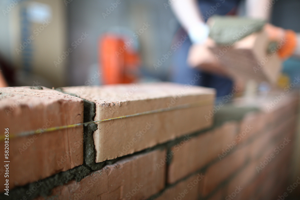 Master builder makes brickwork in house closeup Master builder makes brickwork in house closeup