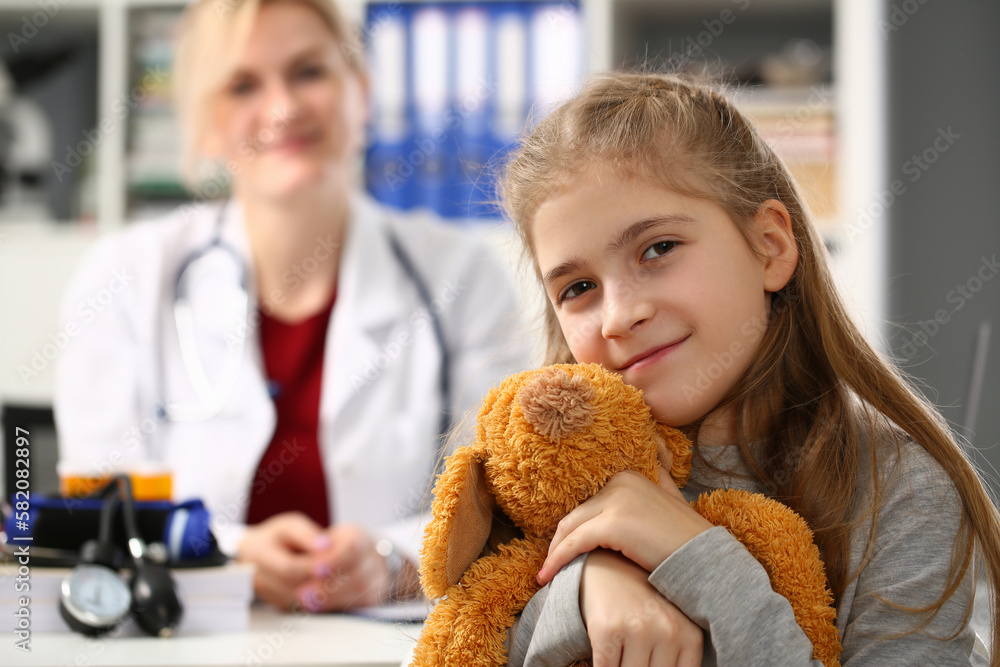 Little girl holding bear toy at medical appointment with pediatrician Little girl holding bear toy at medical appointment with pediatrician