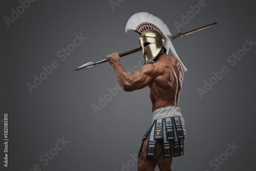 Shot of violent greek spearman holding spear dressed in plumed helmet.