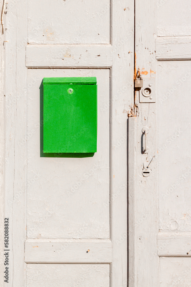 Green box on a brown wooden old door. Nastalgia. Green box on a brown wooden old door. Nastalgia.