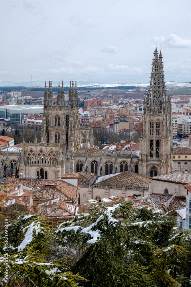 Paisaje de la Catedral de Burgos vista desde el mirador del castillo de la ciudad con todas las casa rodeándola bajo un cielo nublado.