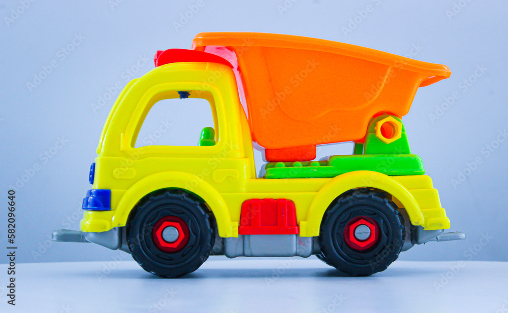 A toy dump truck with different colors isolated with white background. A toy dump truck with different colors isolated with white background.