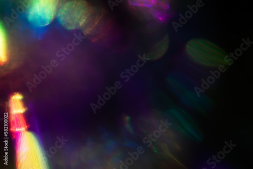 Abstract blurred colorful lens flare bokeh on black,