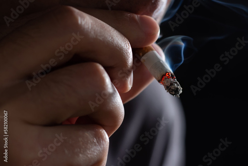 Smoking cigarette in the hand of young man close up