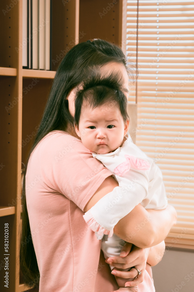 Asian newborn baby holding by mom on shoulder, motherhood lifestyle taking care infant at home, curiosity child girl looking around with innocense, happy woman nurturing baby at home after give birth Asian newborn baby holding by mom on shoulder, motherhood lifestyle taking care infant at home, curiosity child girl looking around with innocense, happy woman nurturing baby at home after give birth