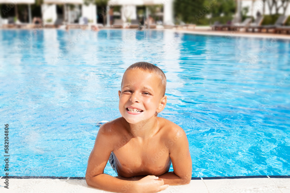 Happy boy in a swimming pool. Summer vacation concept. 