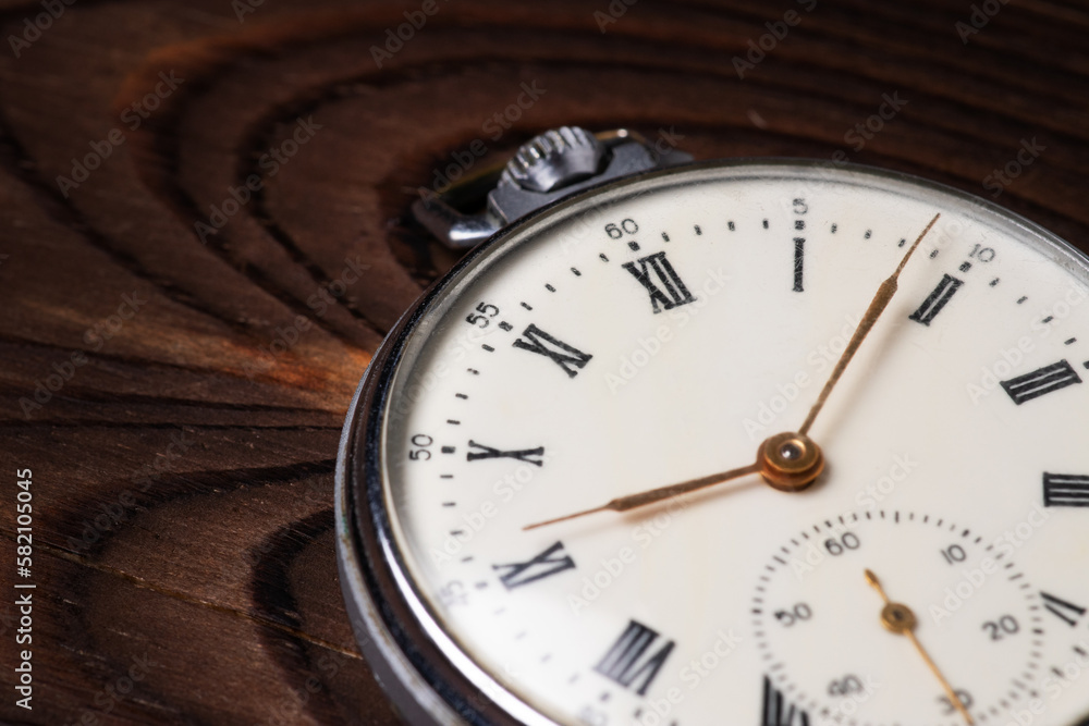 Old pocket watch on wooden background close up Old pocket watch on wooden background close up