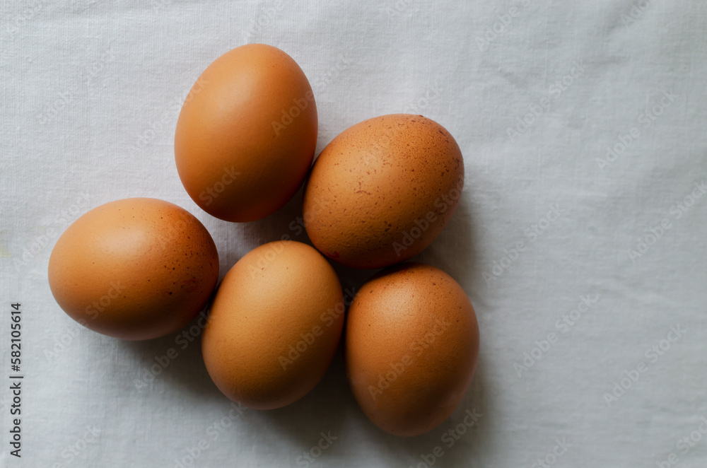Many chicken eggs on a white tablecloth. Rustic style. The concept of organic food. Minimalism. Horizontal orientation. Copy space. Top view Many chicken eggs on a white tablecloth. Rustic style. The concept of organic food. Minimalism. Horizontal orientation. Copy space. Top view