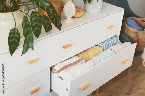 Foto white drawer with stack of warm cozy sweaters