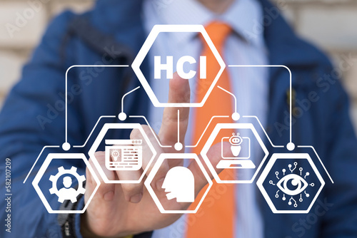 Businessman using virtual touchscreen presses acronym: HCI. HCI - Human Computer Interface business concept.