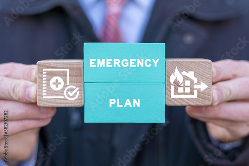Man holding colorful blocks with icons and inscription: EMERGENCY PLAN. Concept of Emergency Preparedness Plan. Business Evacuation Training. Emergency preparedness instructions planning for safety.