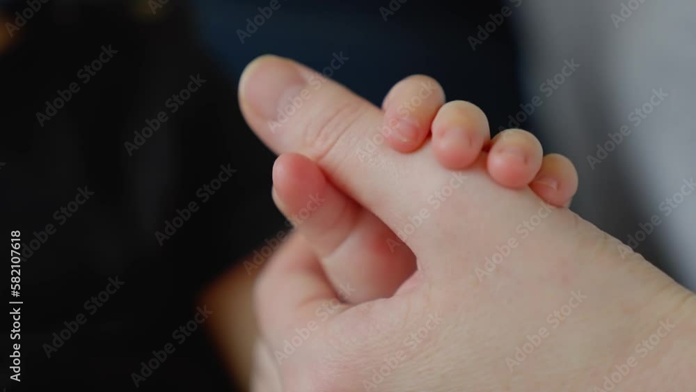 mother holds the hand of a newborn. children hand. hospital takes care of happy family medicine concept. newborn baby holding mom hand close-up. mom takes care baby in close-up the hospital mother holds the hand of a newborn. children hand. hospital takes care of happy family medicine concept. newborn baby holding mom hand close-up. mom takes care baby in close-up the hospital