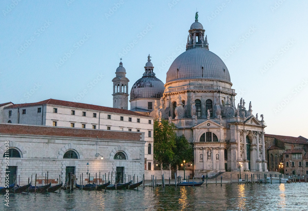 Santa Maria della Salute is a grand basilica located at the entrance to the Grand Canal in Venice, Italy, known for its prominent dome and stunning baroque architecture by night.