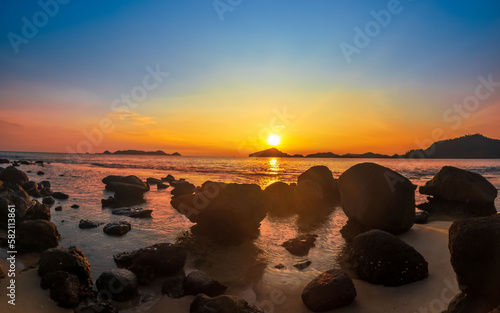 Beach and rocks in seaside. Beautiful dramatic ocean sunset © Johnster Designs