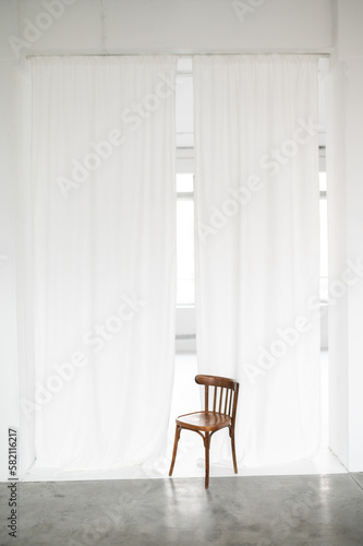 white curtains and old wooden chair in photo studio