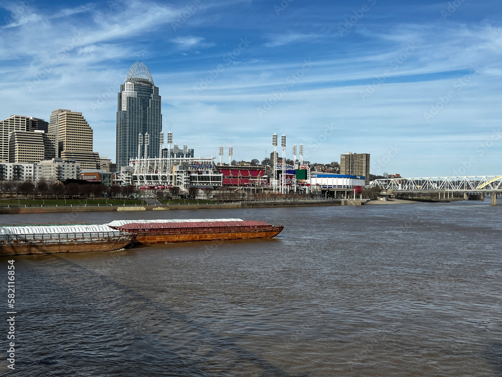 Barge traveling down the Ohio River, with the Cincinnati, Ohio skyline in the background
