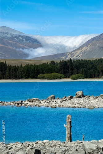 Takapo lake view in south island, new zealand with mountains and sea of clouds in the background