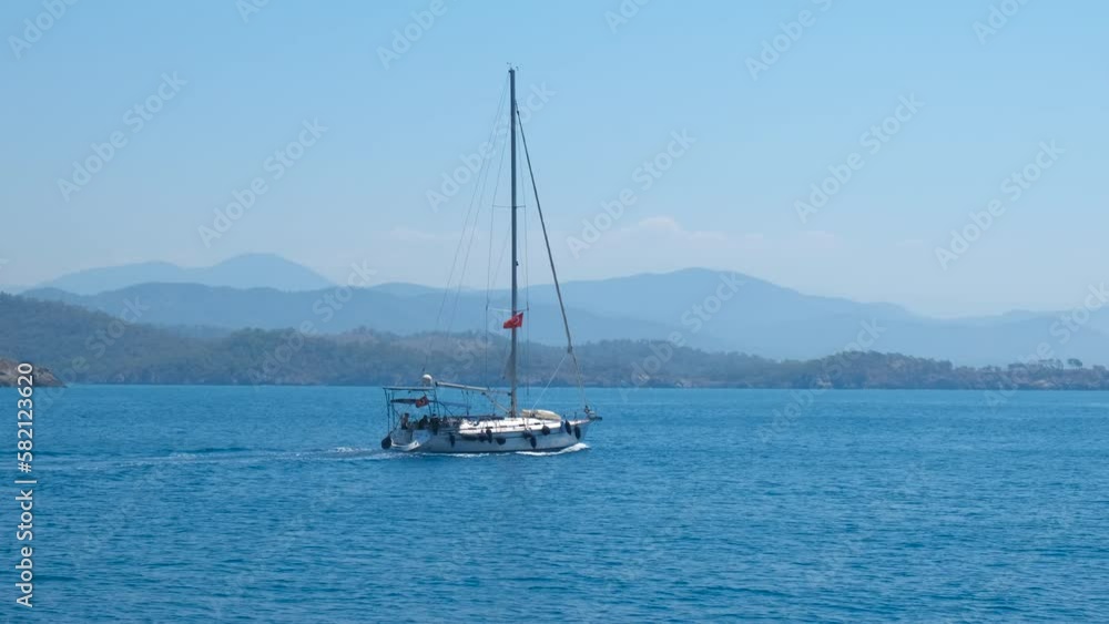 Sailing ship against rocky shoreline. A modern luxury ship sailing against rocky tropical island in the ocean during summer trip. Sailing ship against rocky shoreline. A modern luxury ship sailing against rocky tropical island in the ocean during summer trip.