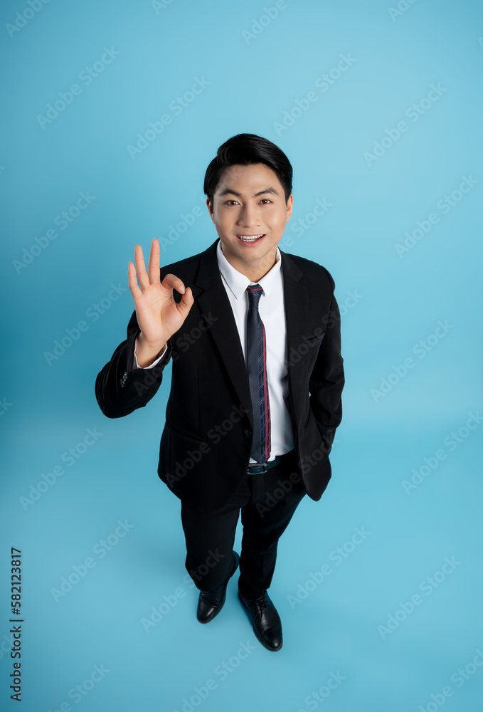 image of young businessman posing on a blue background image of young businessman posing on a blue background