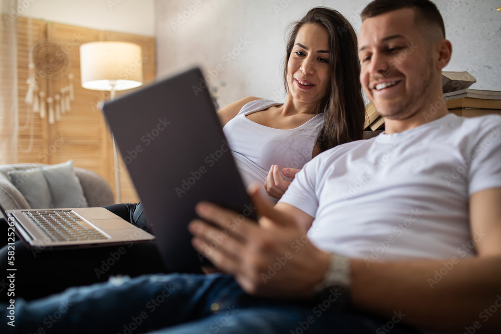 A pregnant woman and her husband buy things online.
