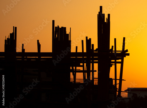 Silhouette building construction at sunset.