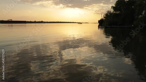 Reflection of a sunset in the clouds in the water surface of the Danube River, a beautiful evening in the city of Vilkovo in southern Ukraine photo