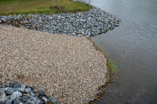 pond sluice, water reservoirs with regulation and concrete dam shaft. guide profiles determining flow, outflow under dam pipe. railing and bridge leading over water. service stone block staircase