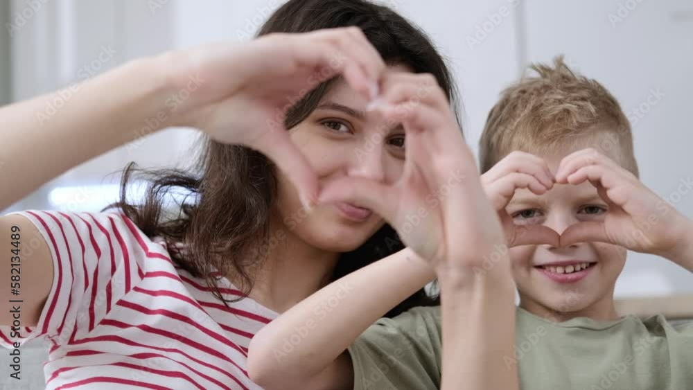 Close up portrait happy family of two making hands heart gesture, on smiling young mother bonding little cute son, overjoyed small boy showing love sign with millennial mommy at home Close up portrait happy family of two making hands heart gesture, on smiling young mother bonding little cute son, overjoyed small boy showing love sign with millennial mommy at home