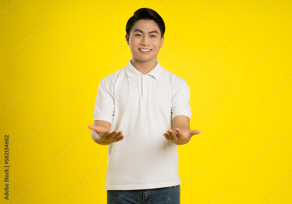 Portrait of young asian man posing on yellow background Portrait of young asian man posing on yellow background