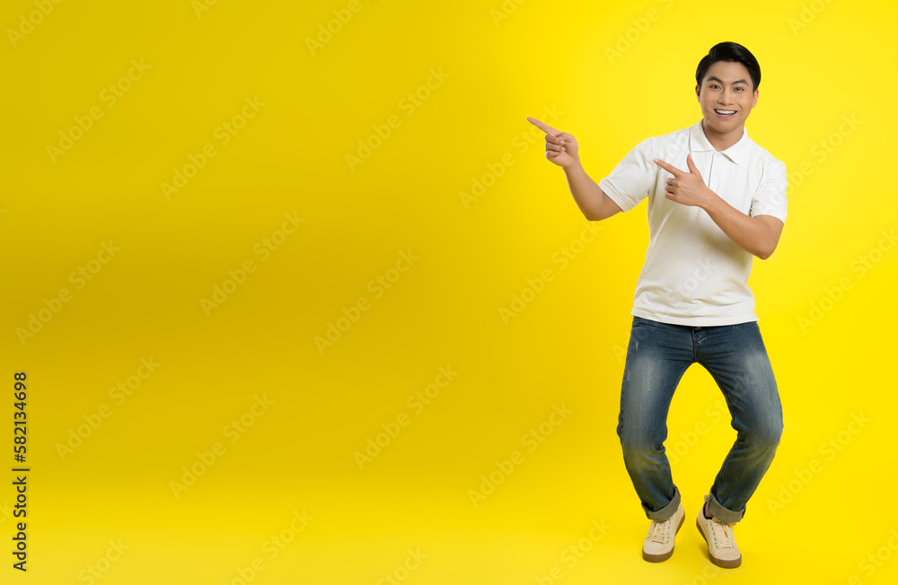Portrait of young asian man posing on yellow background
