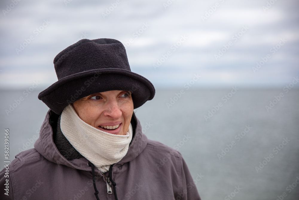 Happy, active older woman at the beach in Winter. High quality photo